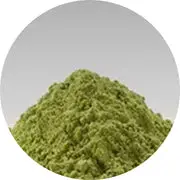 A mound of green powder against a plain gray background.