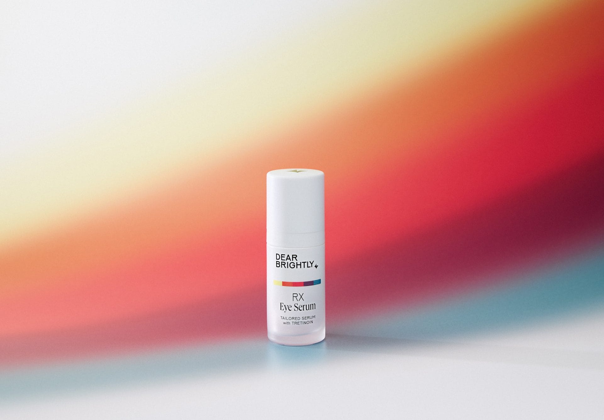 A bottle of Rx Eye Serum on a rainbow background
