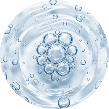 A circular drop of clear liquid containing a cluster of air bubbles.